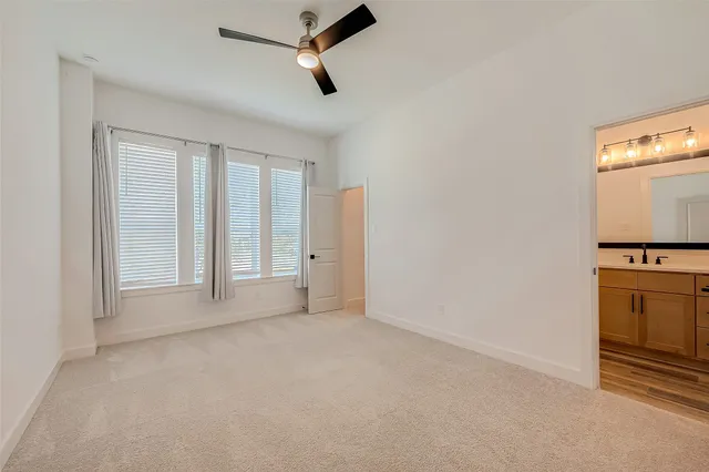 an empty room with windows cabinet and fireplace