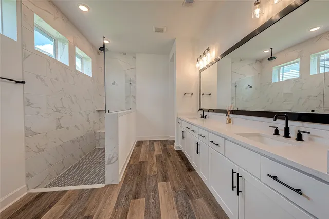 a large white bathroom with a double vanity sink and mirror