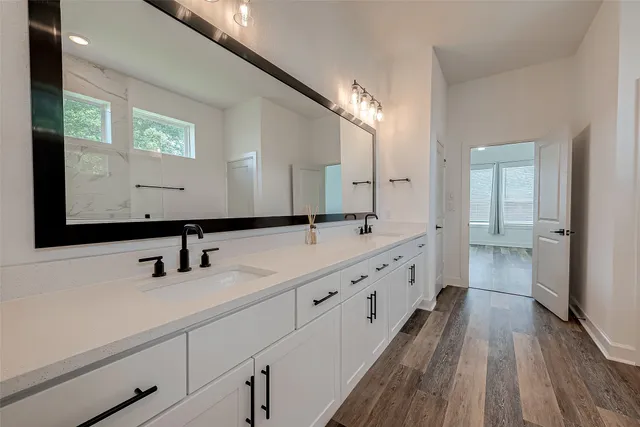 a bathroom with double vanity and a mirror