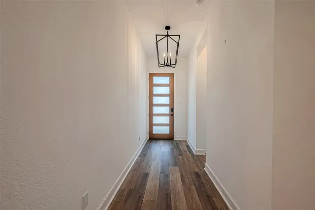 a view of a hallway with wooden floor and cabinet