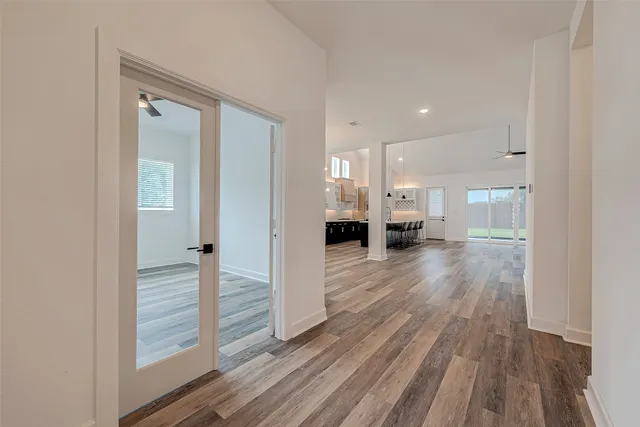 a view of a hallway with wooden floor windows and a living room