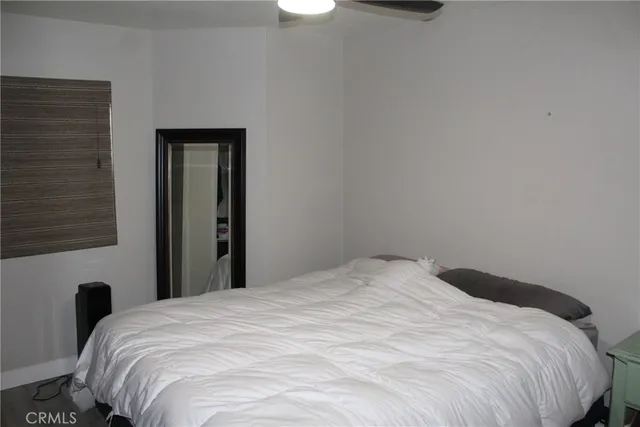 a large bed in a bedroom next to a window