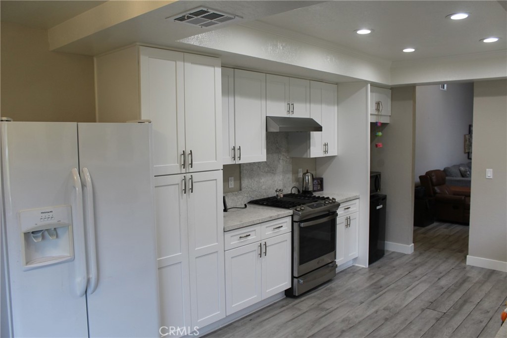 8267 San Bernardino Road Rancho Cucamonga, CA 91730 - Photo 4 of 32 a kitchen with stainless steel appliances granite countertop a refrigerator and a stove top oven