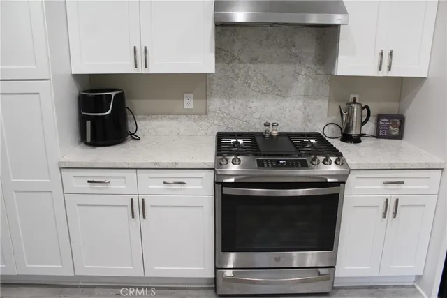 a kitchen with white cabinets and appliances