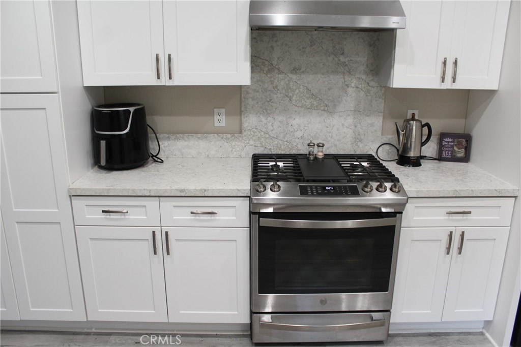 8267 San Bernardino Road Rancho Cucamonga, CA 91730 - Photo 5 of 32 a kitchen with white cabinets and appliances