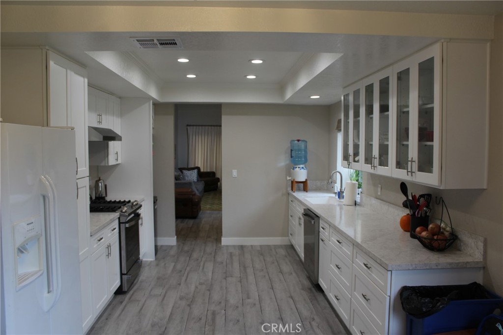 8267 San Bernardino Road Rancho Cucamonga, CA 91730 - Photo 7 of 32 a kitchen with granite countertop a refrigerator stove top oven and sink