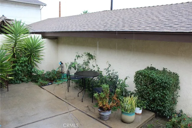 a backyard of a house with plants and outdoor seating