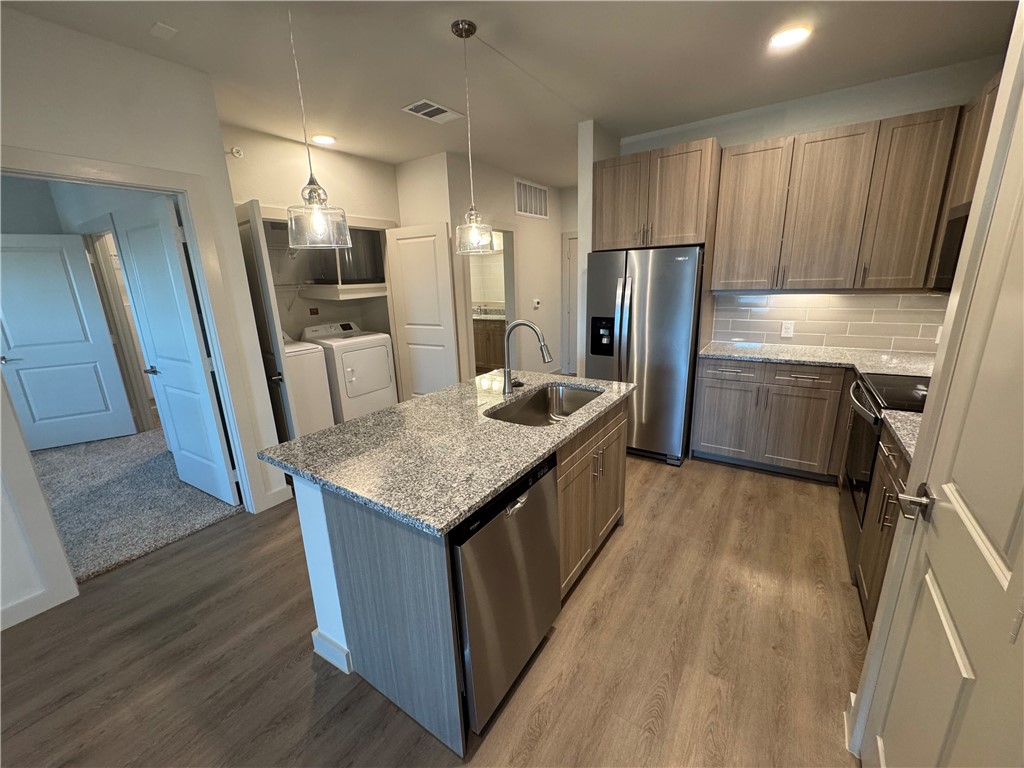 6000 Jones Road, Unit 4202 Bryan, TX 77807 - Photo 12 of 20 a kitchen with refrigerator and wooden floor