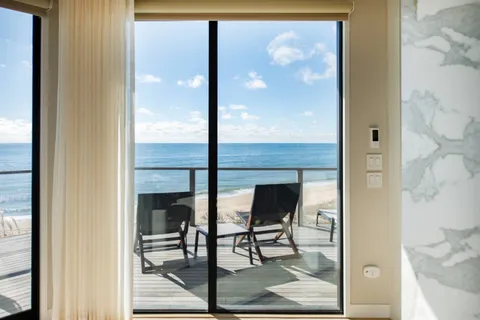 a view of a hallway with wooden floor and dining room view