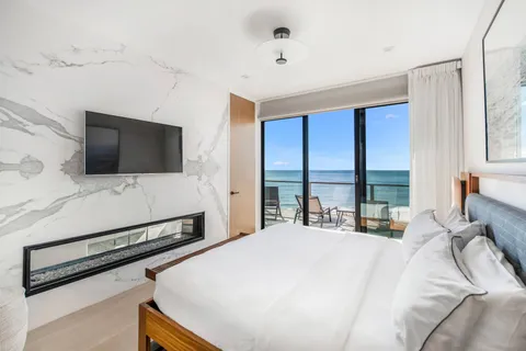 a large bedroom with a bed and a flat screen tv