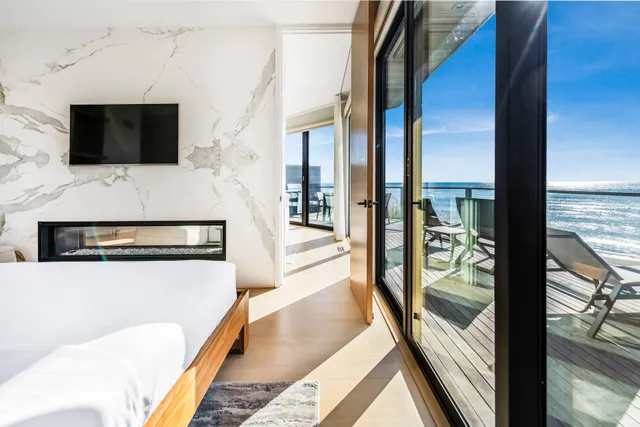 a living room with stainless steel appliances furniture and a fireplace