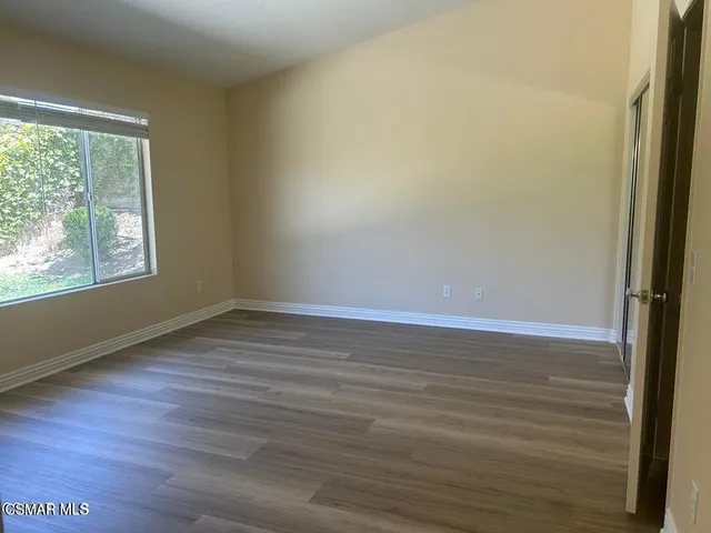 a view of a room with wooden floor and window