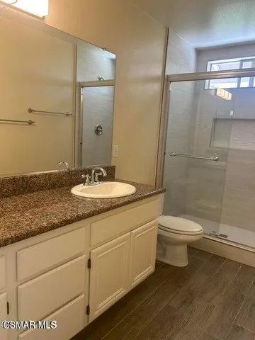 a bathroom with a granite countertop sink toilet and shower