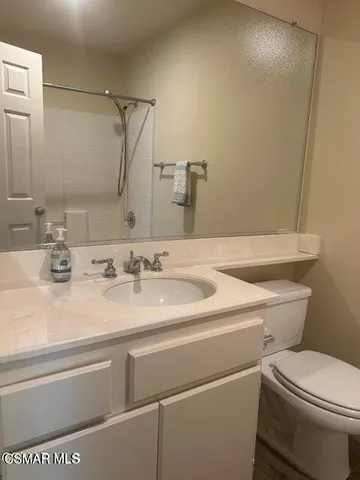 a bathroom with a sink a toilet and mirror