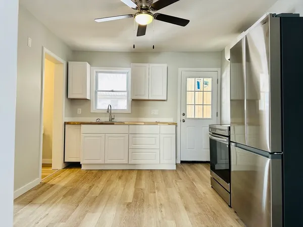 a kitchen with a refrigerator a sink and dishwasher with wooden floor