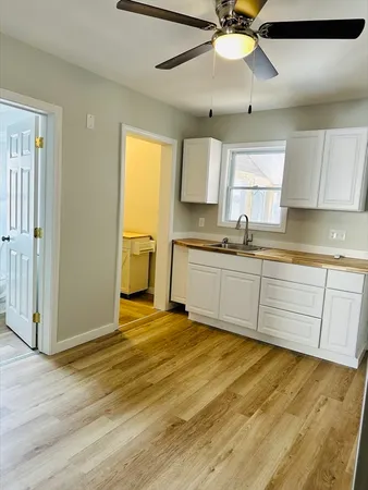 a kitchen with stainless steel appliances granite countertop a sink cabinets and wooden floor