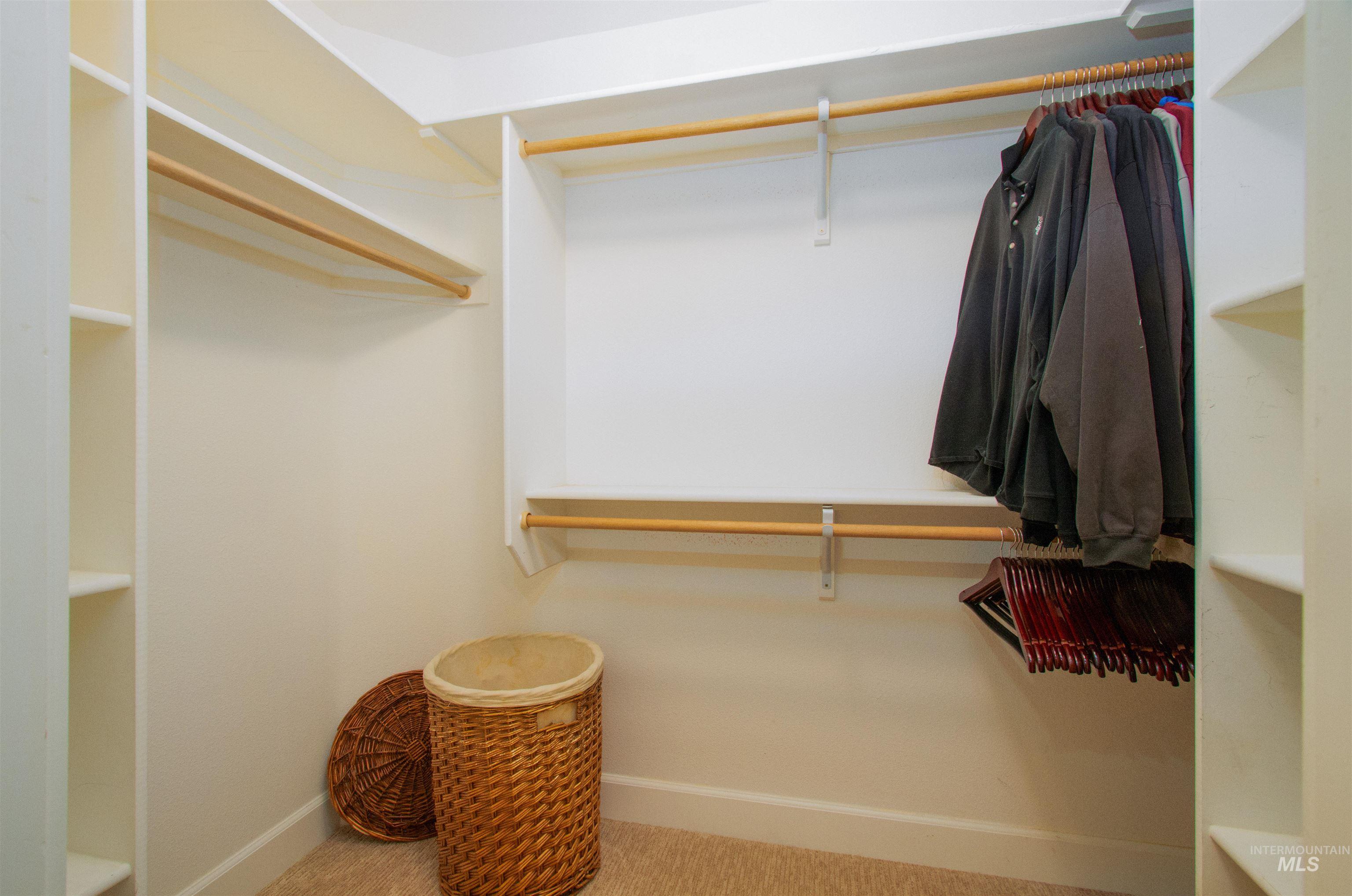892 South Capitola Way Boise, ID 83712 - Photo 10 of 34 Walk-in closet featuring built-in shelving, multiple hanging rods, and neutral-toned carpeting