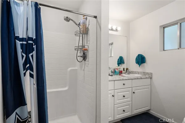 a bathroom with a sink a mirror a vanity and shower