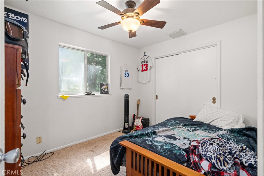 9803 Cohasset Road Chico, CA 95973 - Photo 14 of 22 a bedroom with a bed and a chandelier