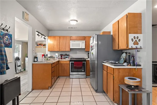 a kitchen with stainless steel appliances kitchen island granite countertop a refrigerator and a stove top oven