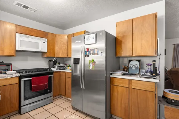 a kitchen with stainless steel appliances granite countertop a refrigerator sink and stove