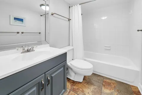 a bathroom with a sink a toilet a mirror and shower