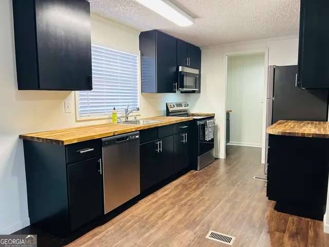 a kitchen with a sink and wooden floor