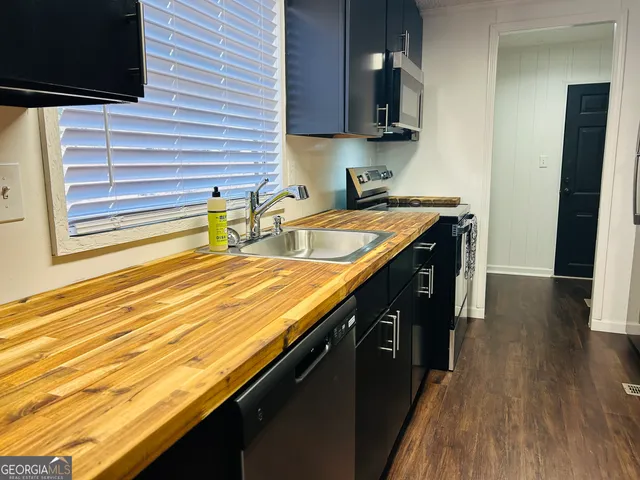 a kitchen with stainless steel appliances granite countertop a refrigerator and a sink