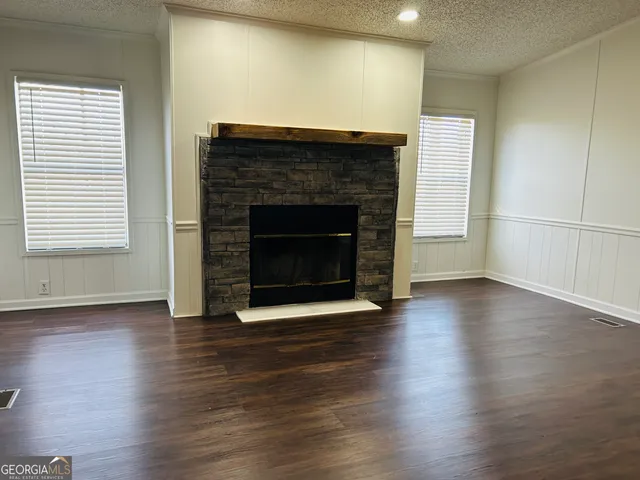 a view of a livingroom with wooden floor and a fireplace