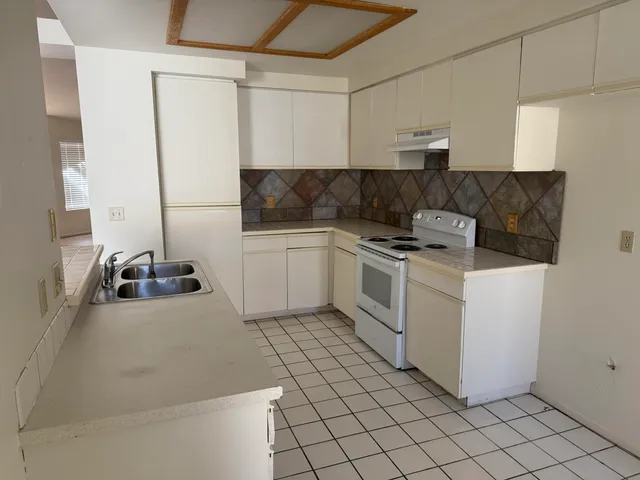 a kitchen with a sink appliances and cabinets