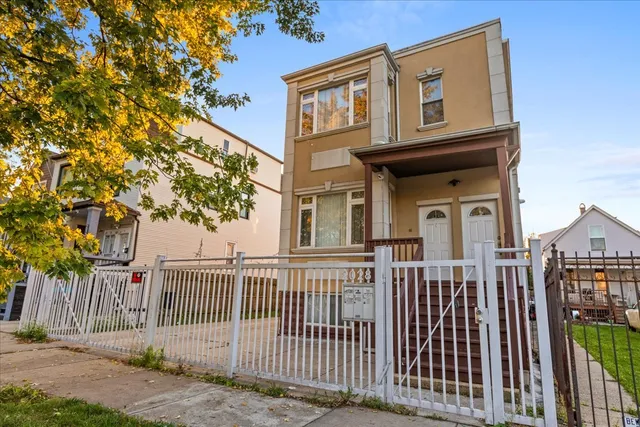 a view of a brick house front of fence