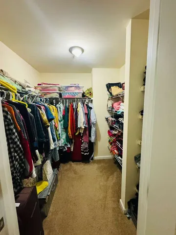 a view of walk in closet with clothes