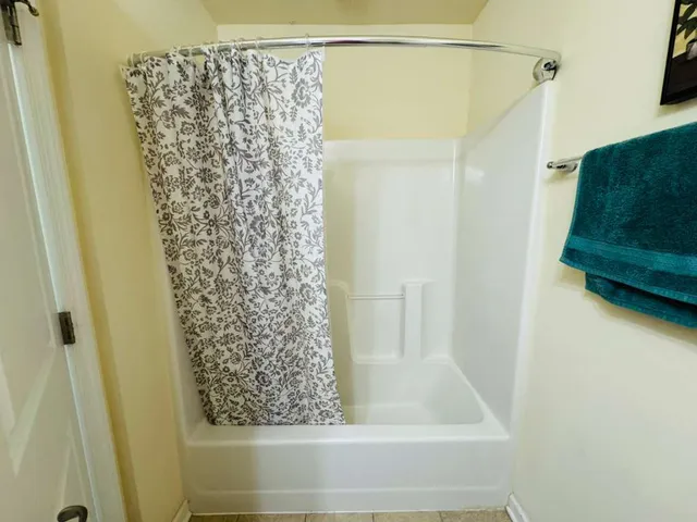 a bathroom with a shower curtain and a window