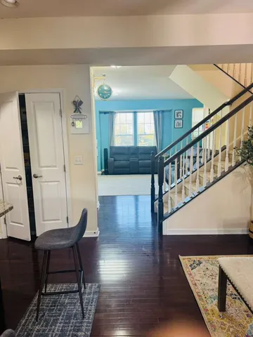 a view of a hallway with wooden floor and stairs