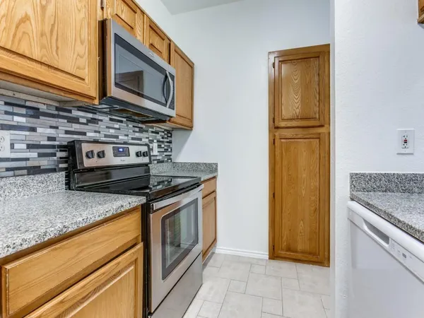 a kitchen with granite countertop cabinets stainless steel appliances and a counter space
