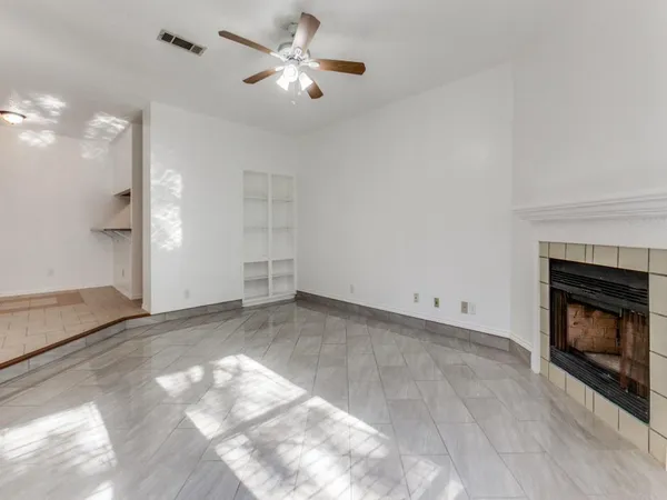 a view of empty room with fireplace and fan