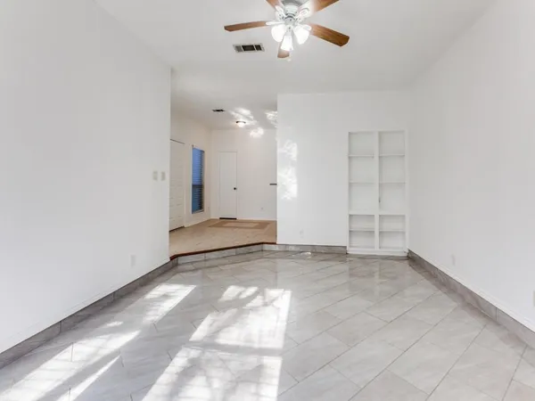 an empty room with fan and windows