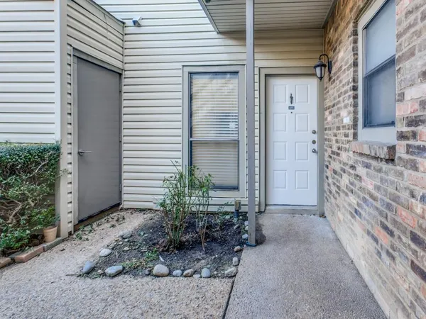 a view of house with chair and potted plants