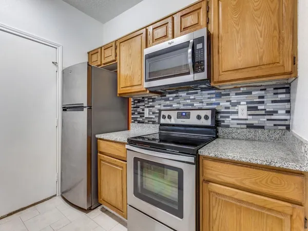 a kitchen with granite countertop cabinets stainless steel appliances and a counter space