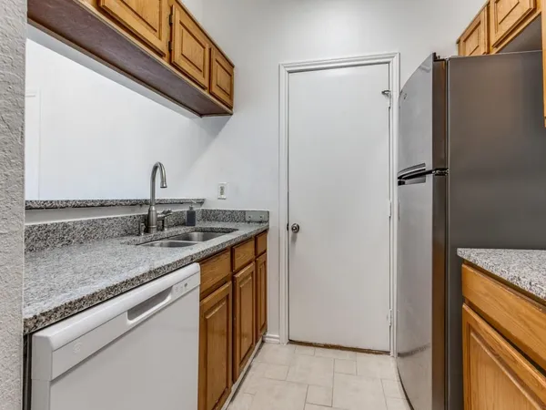 a kitchen with stainless steel appliances granite countertop a refrigerator and a sink