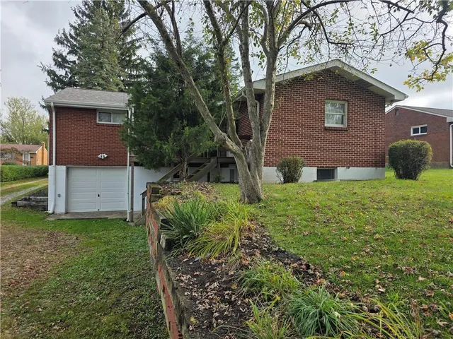 a yellow house with green field in front of it