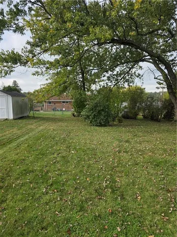 a view of a field of grass and trees