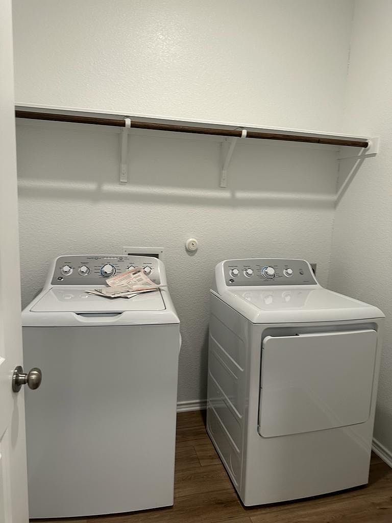 160 River Rise Road Kyle, TX 78640 - Photo 10 of 35 Dedicated laundry space featuring wood-finish flooring, a white interior, and an overhead storage shelf