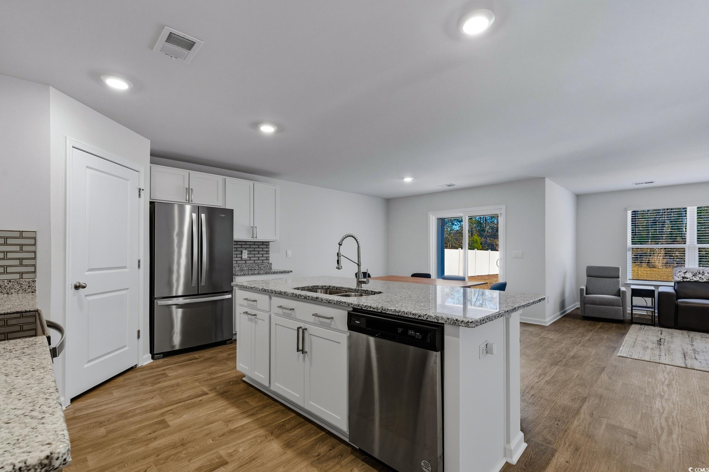 256 Country Grove Way Galivants Ferry, SC 29544 - Photo 4 of 22 Kitchen with appliances with stainless steel finishes, light stone counters, light wood-style flooring, a kitchen island with sink, and recessed lighting