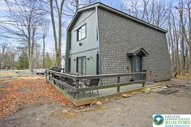 a view of a house with a yard and wooden fence