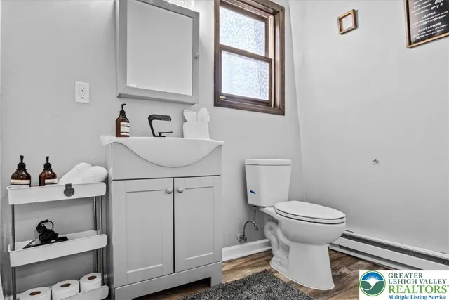 a bathroom with a sink toilet and a window