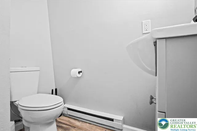 a white toilet sitting next to a shower