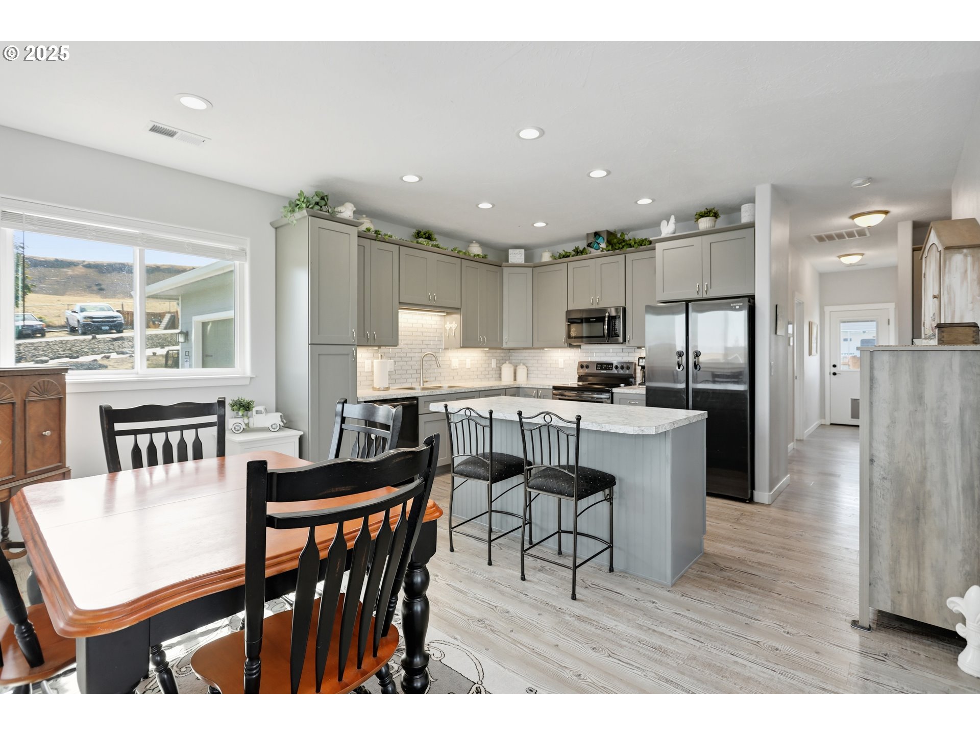 1275 Wright Road Arlington, OR 97812 - Photo 23 of 34 a kitchen with stainless steel appliances kitchen island granite countertop a table chairs refrigerator and sink
