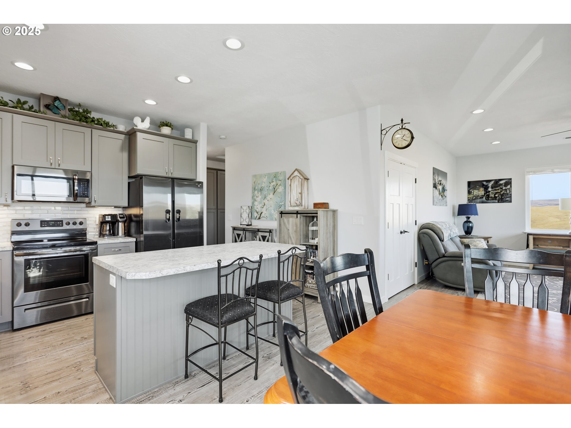 1275 Wright Road Arlington, OR 97812 - Photo 27 of 34 a kitchen with stainless steel appliances kitchen island granite countertop a table chairs microwave and sink