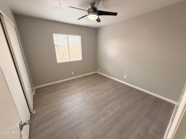 an empty room with windows and fan